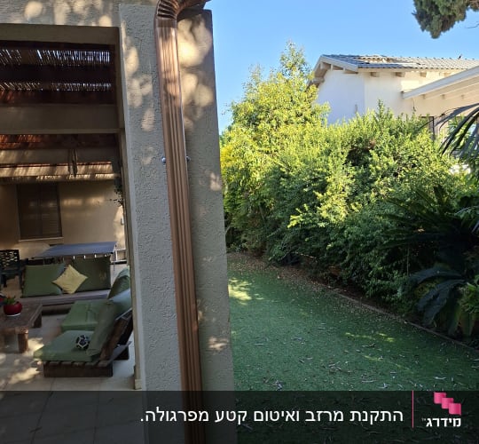 מרזב חיצוני מותקן על קיר ליד גינה